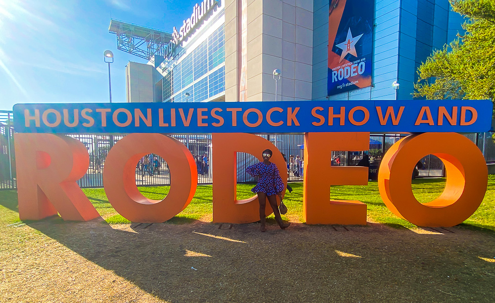 Jazzmine standing in front of Houston Livestock Show and Rodeo sign.