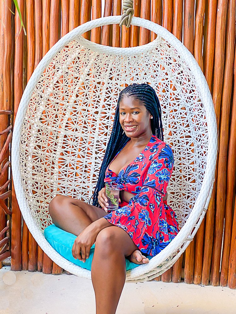 Jazzmine sitting in white egg chair on hotel balcony