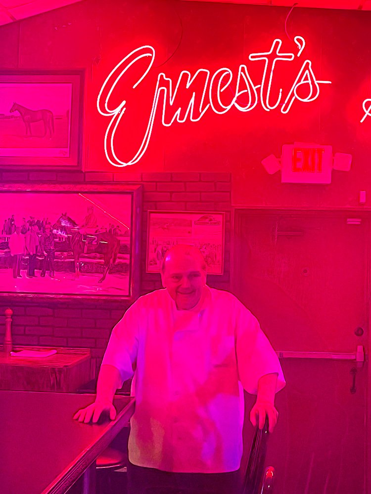 Chef Ernest posing in front of Ernest Orleans sign.