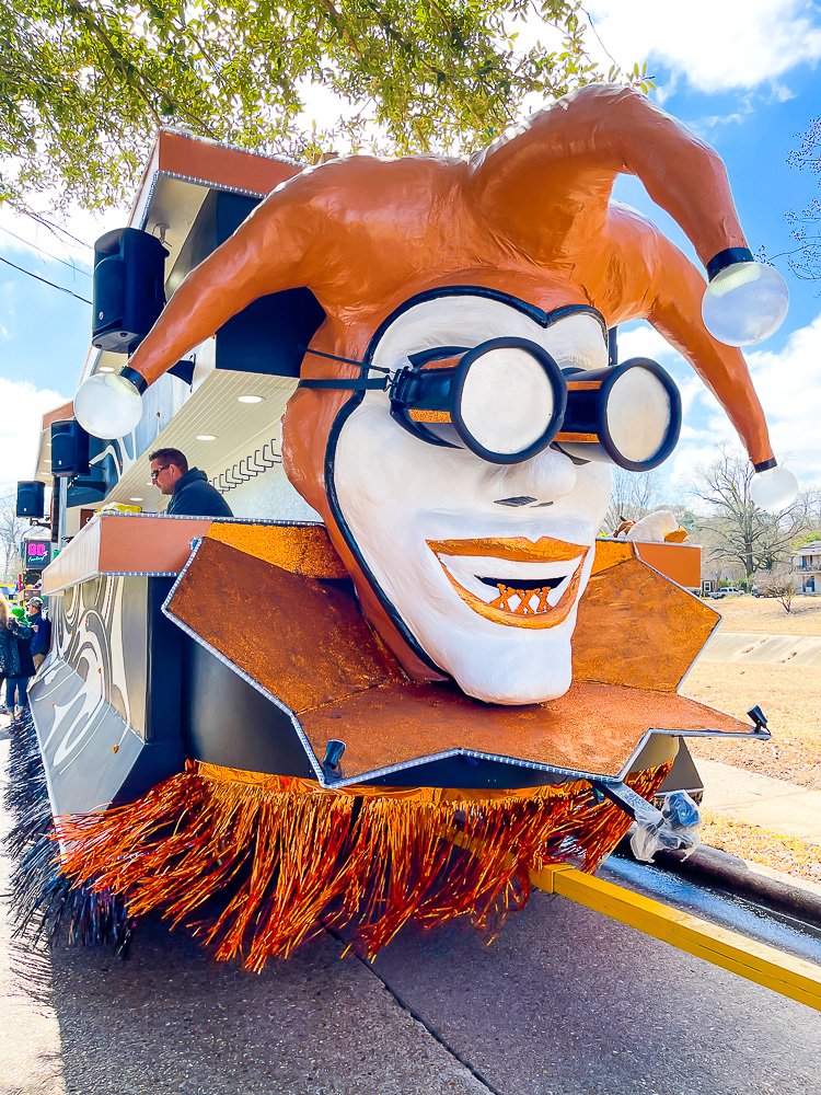 orange and white decorated float at Mardi Gras parade.