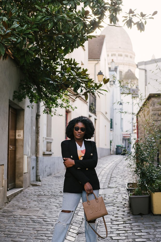 Jazzmine standing in alley with dome of Sacre Cour in background.