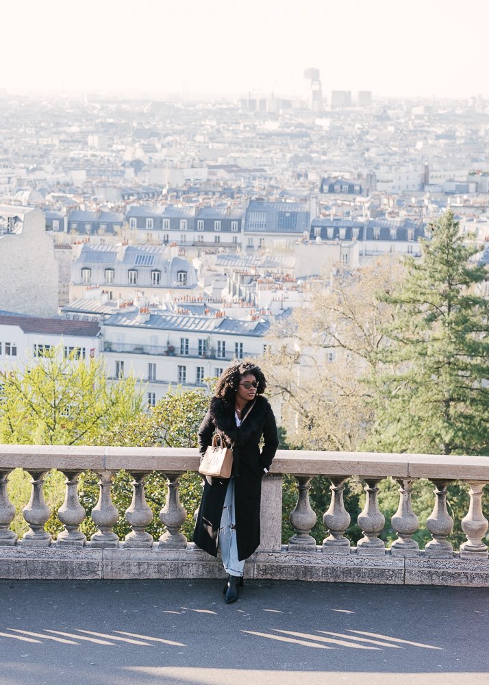 Jazzmine leaned against railing with city of Paris in background.