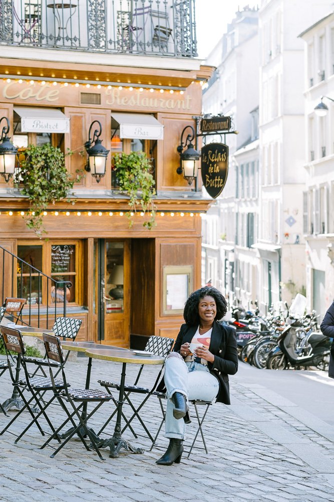 Jazzmine sitting outside Parisian cafe.