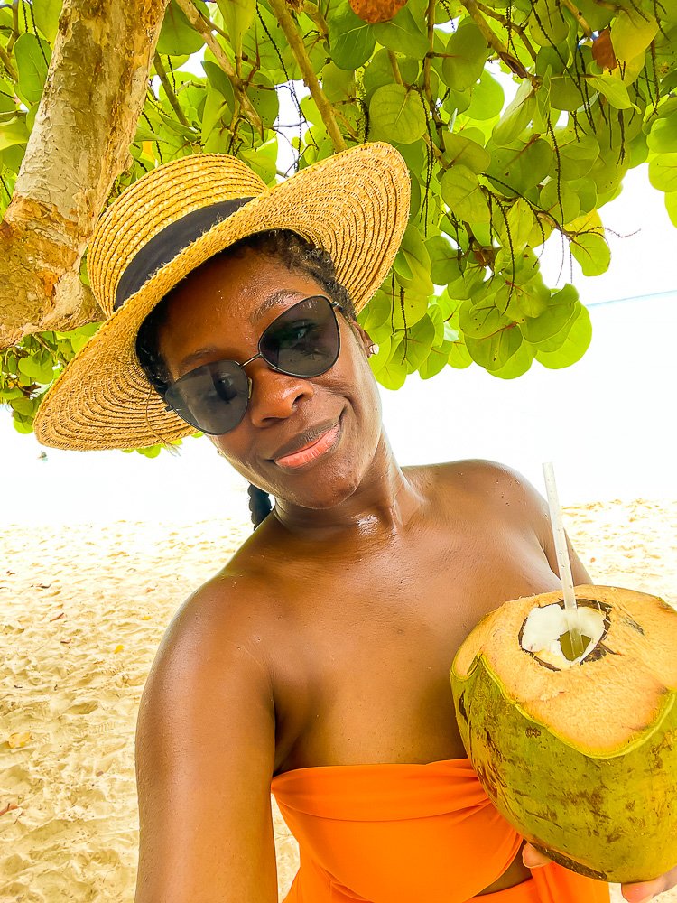 Jazzmine holding fresh coconut cut for drinking.