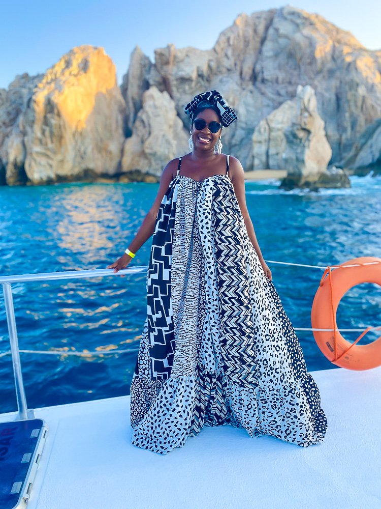 Jazzmine posing on catamaran with Arco de Los Cabos in background.