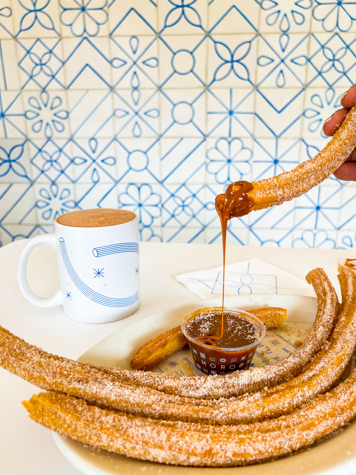dipping giant churros in cajeta while dining alone in Mexico City, Mexico.