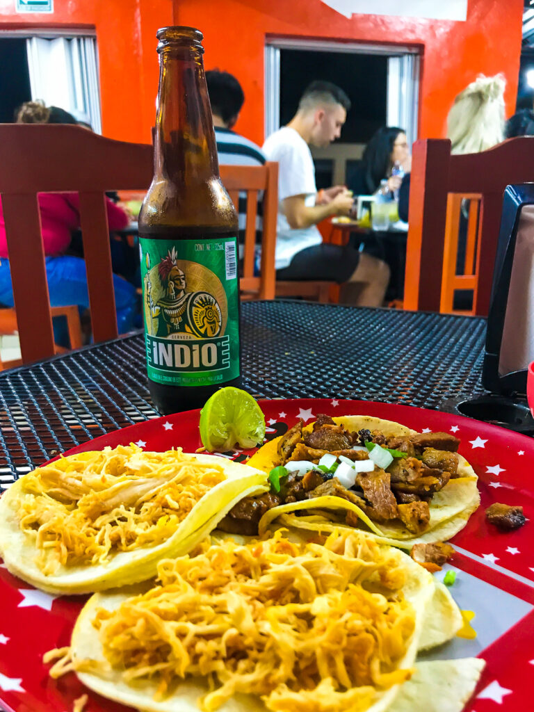 plate of 50 cent street tacos with a bottle of Indio beer at Antojiotos la Chiapaneca in Tulum Centro, Quintana Roo.