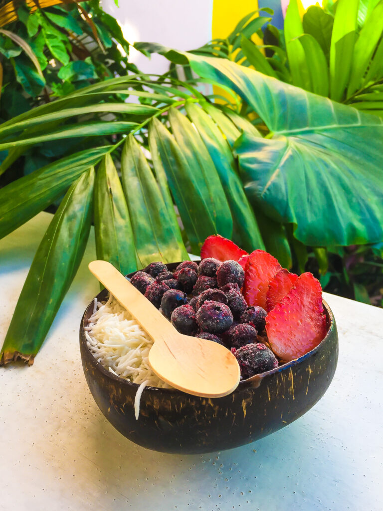 acai smoothie bowl with frozen blueberries, strawberry slices, and shredded coconut on top at Matcha Mama Tulum Pueblo.