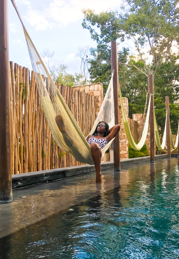 Jazzmine lounging in hammock at Amaka Calma Tulum hotel pool.