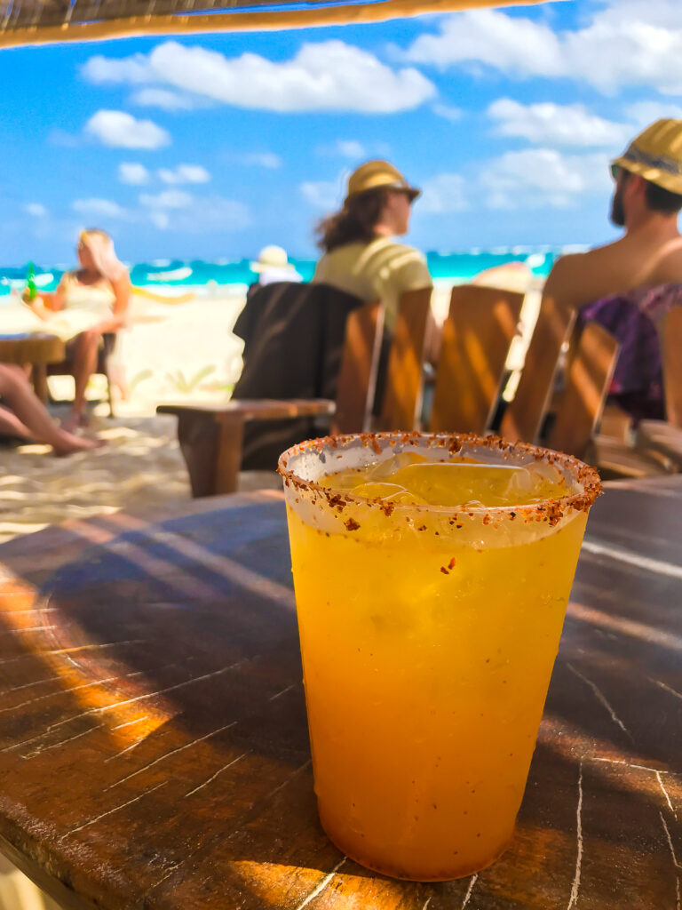 passion fruit margarita on the rocks with tajin salted rim at Villa Pescadores beach club in Tulum.