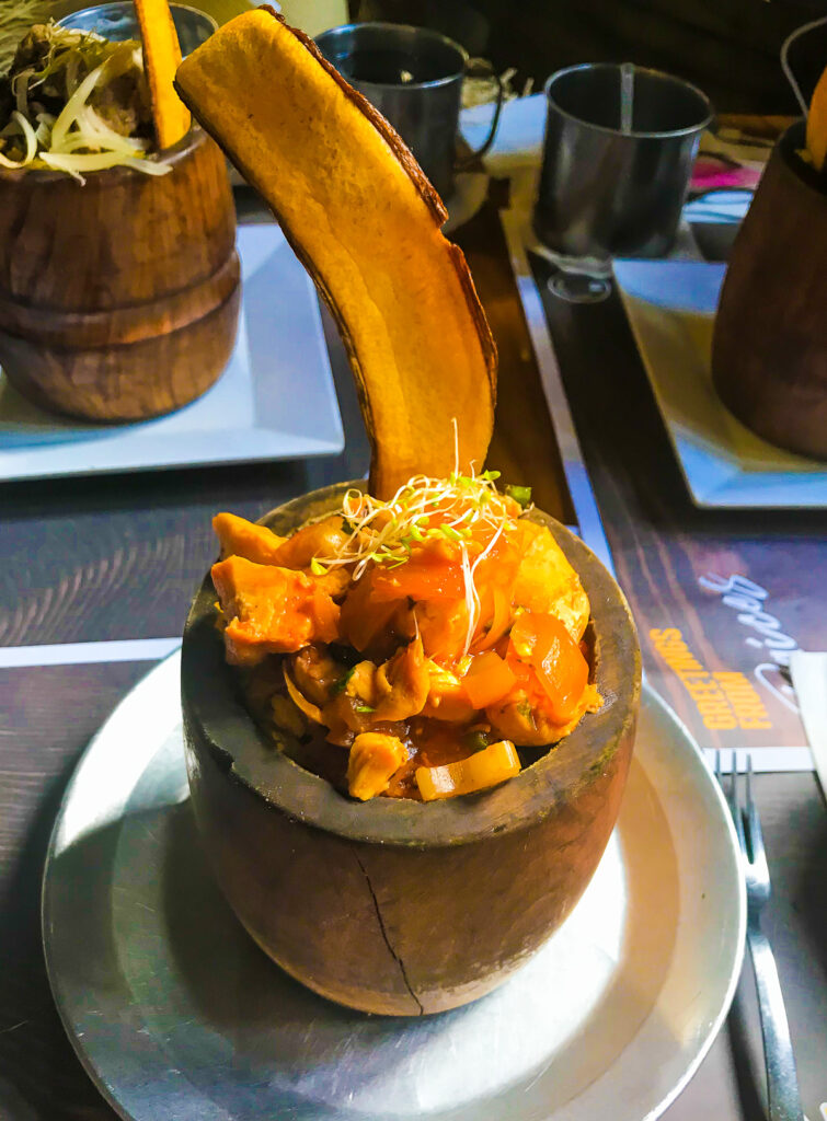 traditional Puerto Rican mofongo served in deep wooden dishes with micro greens and long fried plantain crisp at Raices Old San Juan restaurant.