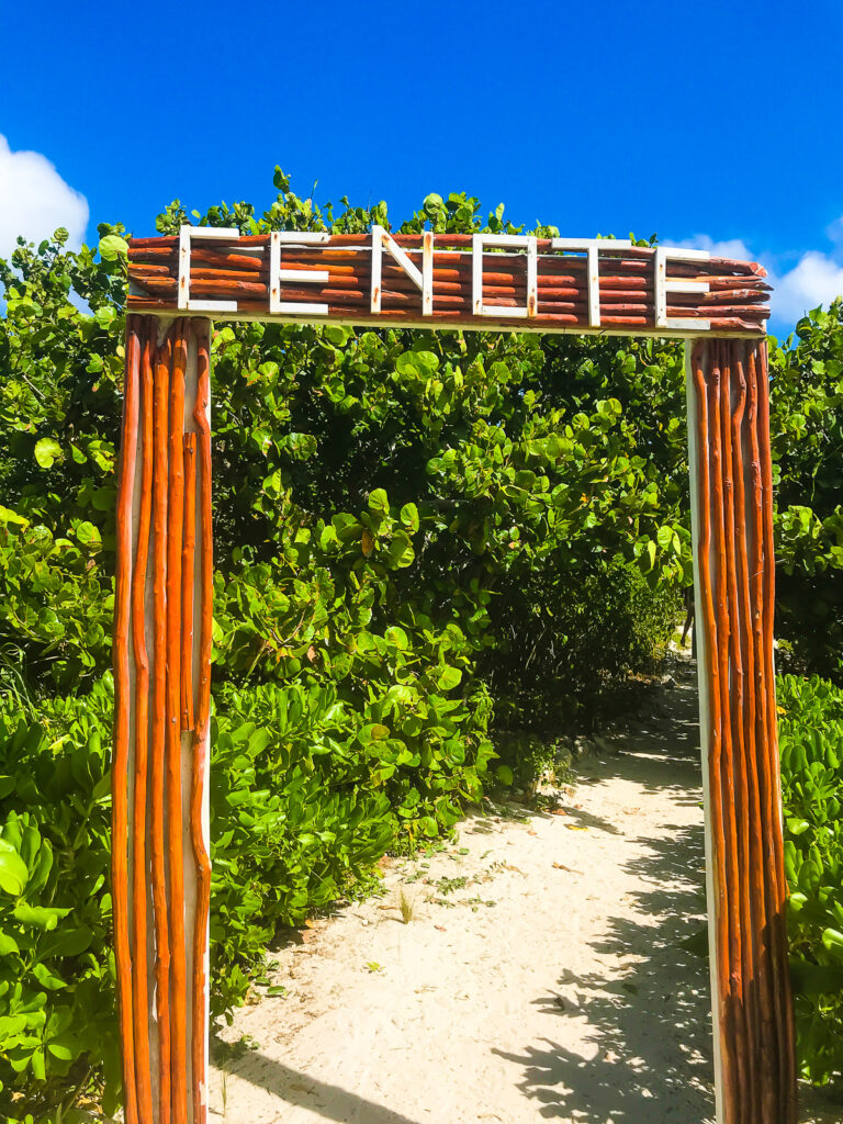 wooden sign with white letters that read "cenote" at the entrance to Tulum cenote in Quintana Roo Riviera Maya region.