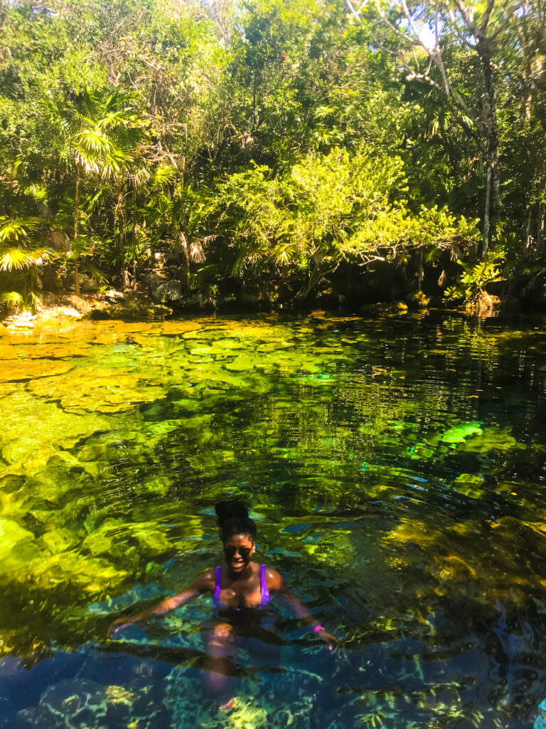 Jazzmine swimming in blue green cenote water in Mexico's Yucatan Region in Tulum.