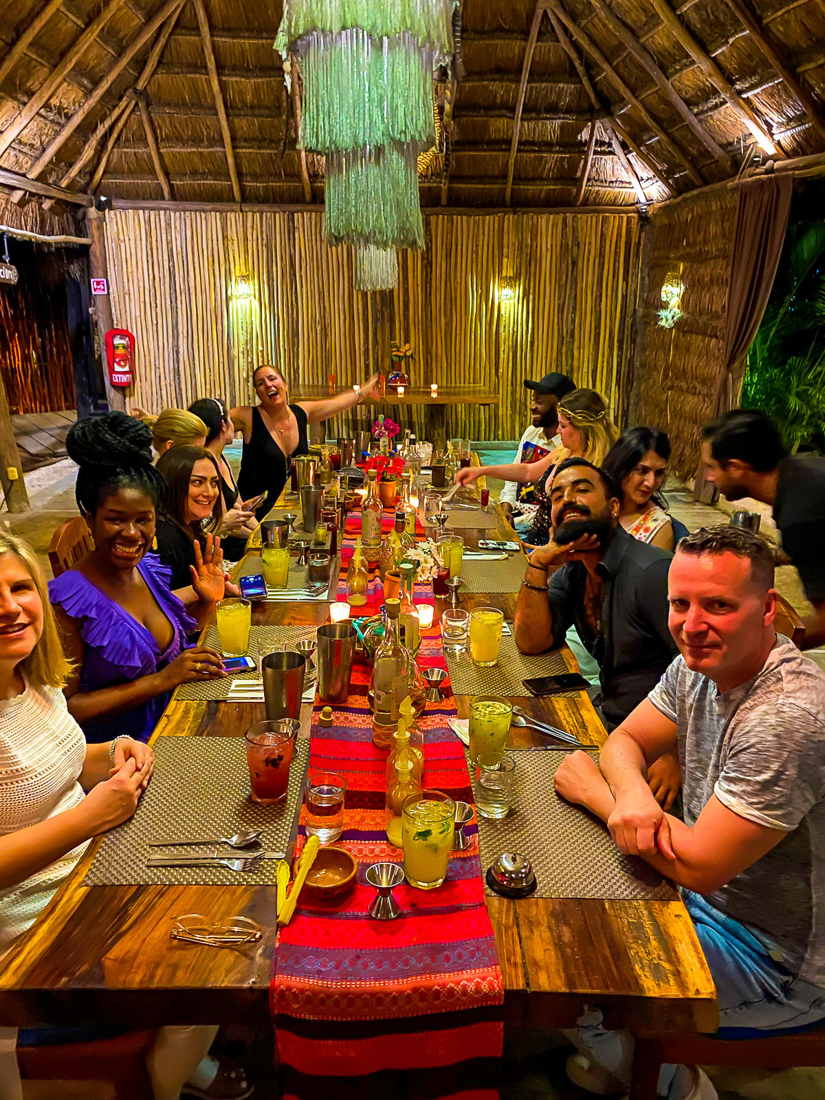 Jazzmine sitting at a table full of fellow travelers at an immersive Mexican dining experience in Tulum, Mexico.