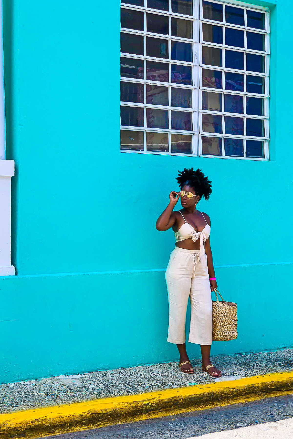 Jazzmine standing against a bright turquoise wall in Santurce, PR.