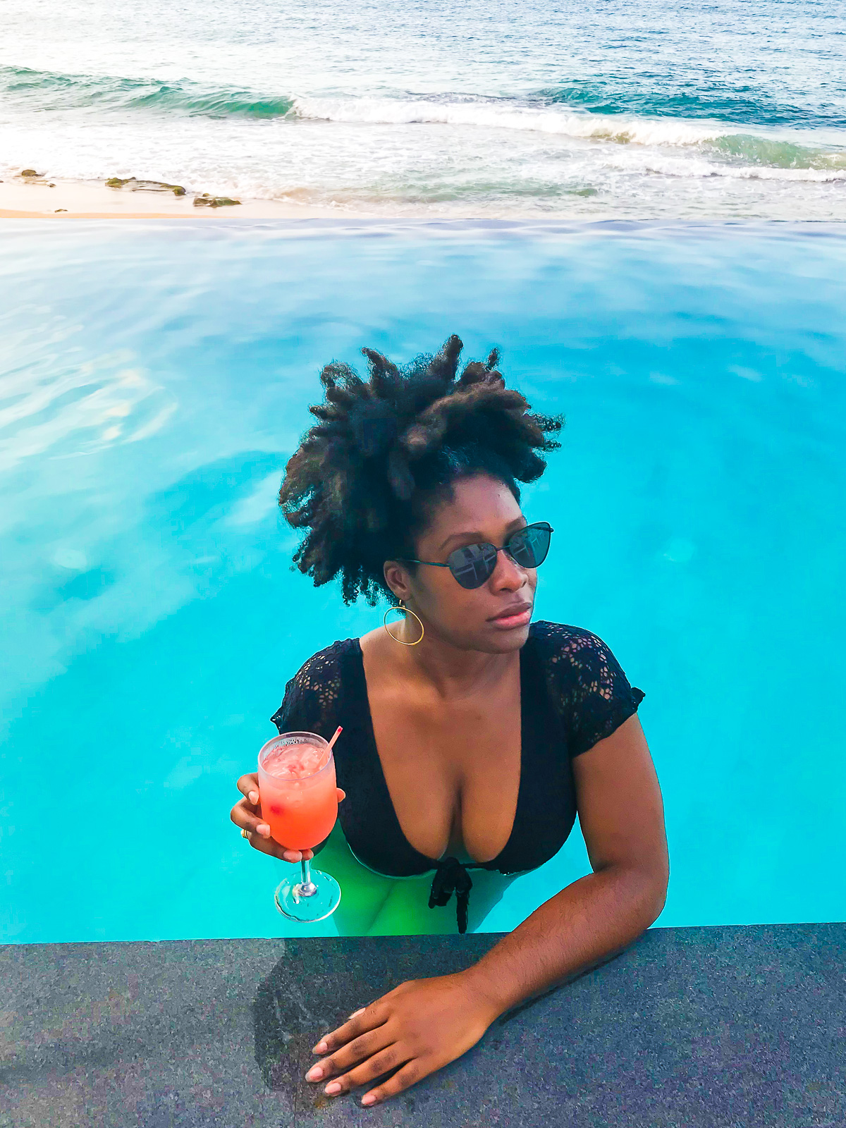 Jazzmine holding rum punch cocktail while standing in the infinity pool at Condado Beach Club Puerto Rico.