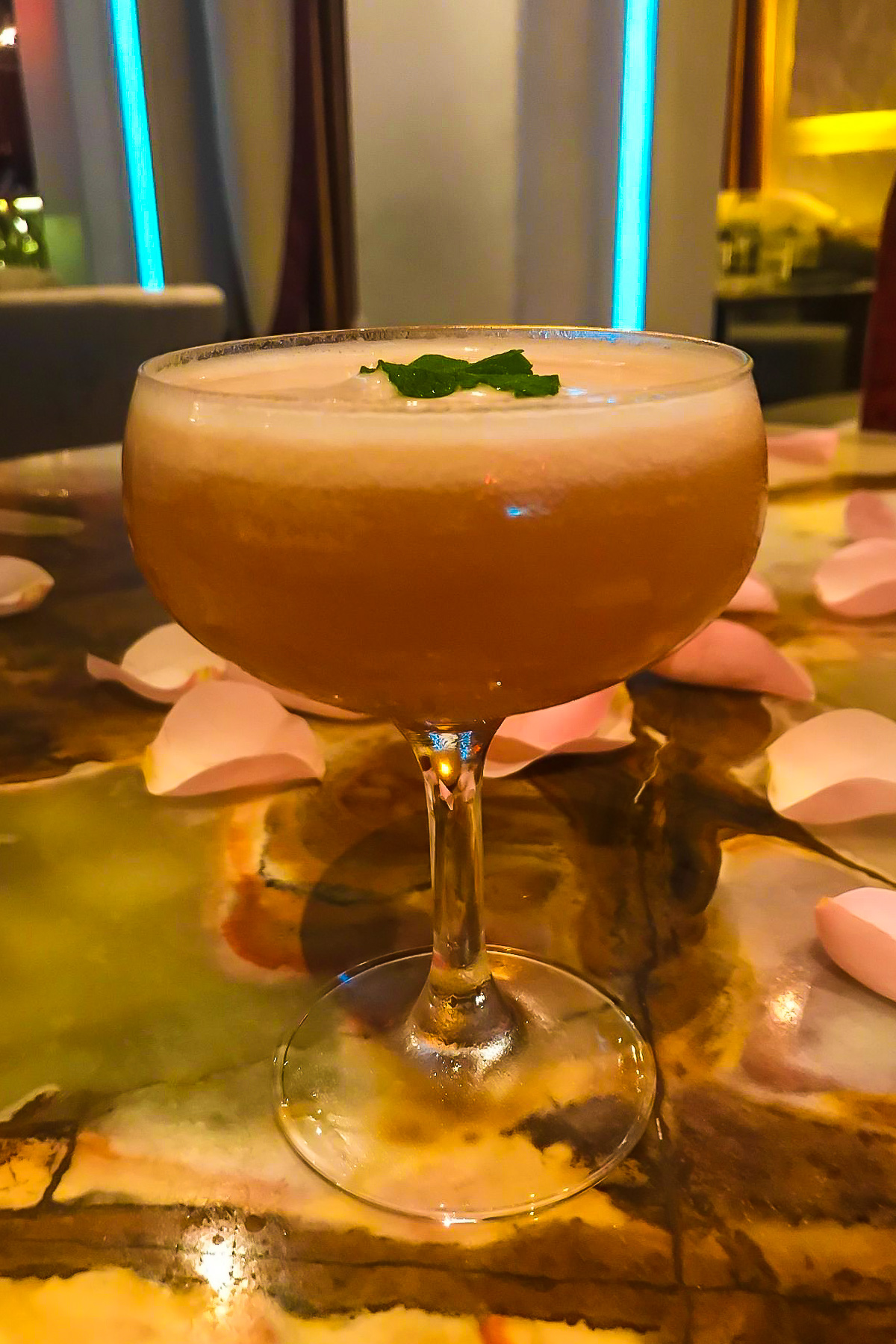 cocktail garnished with fresh mint surrounded by pink rose petals at Marmalade Restaurant, PR.