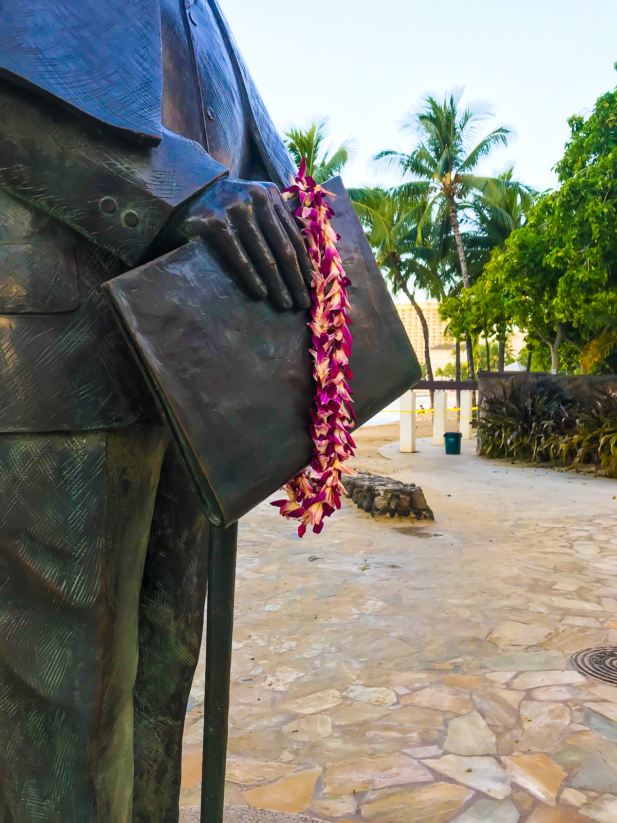 dried lei resting on statue of Prince Jonah Kūhiō Kalanianaʻole near Waikiki Beach.