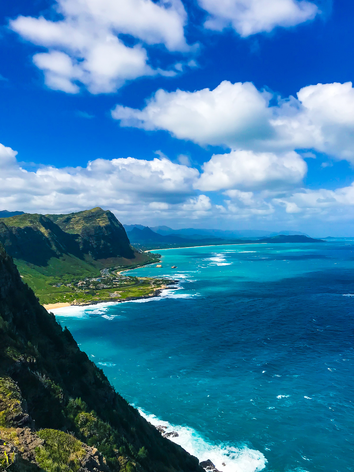 lush green mountains and deep blue water off the coast of Oahu, Hawaii.