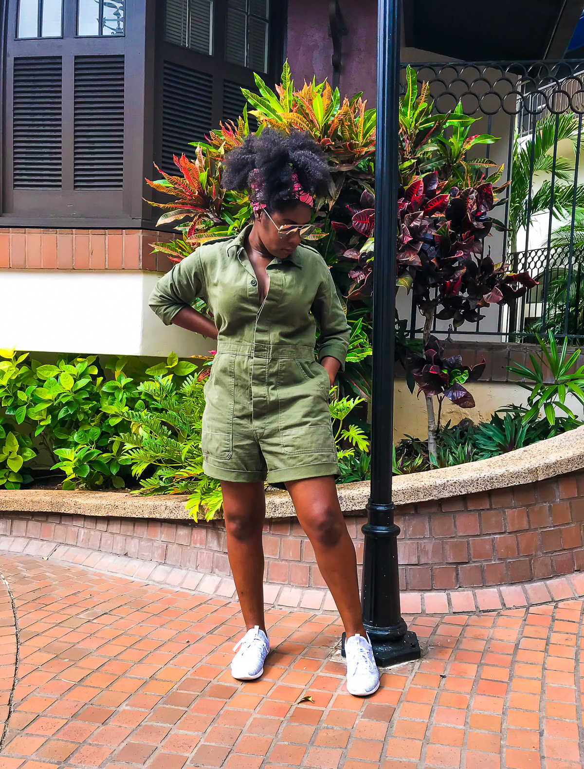 Jazzmine in downtown Honolulu wearing an olive green short flight suit-style romper.