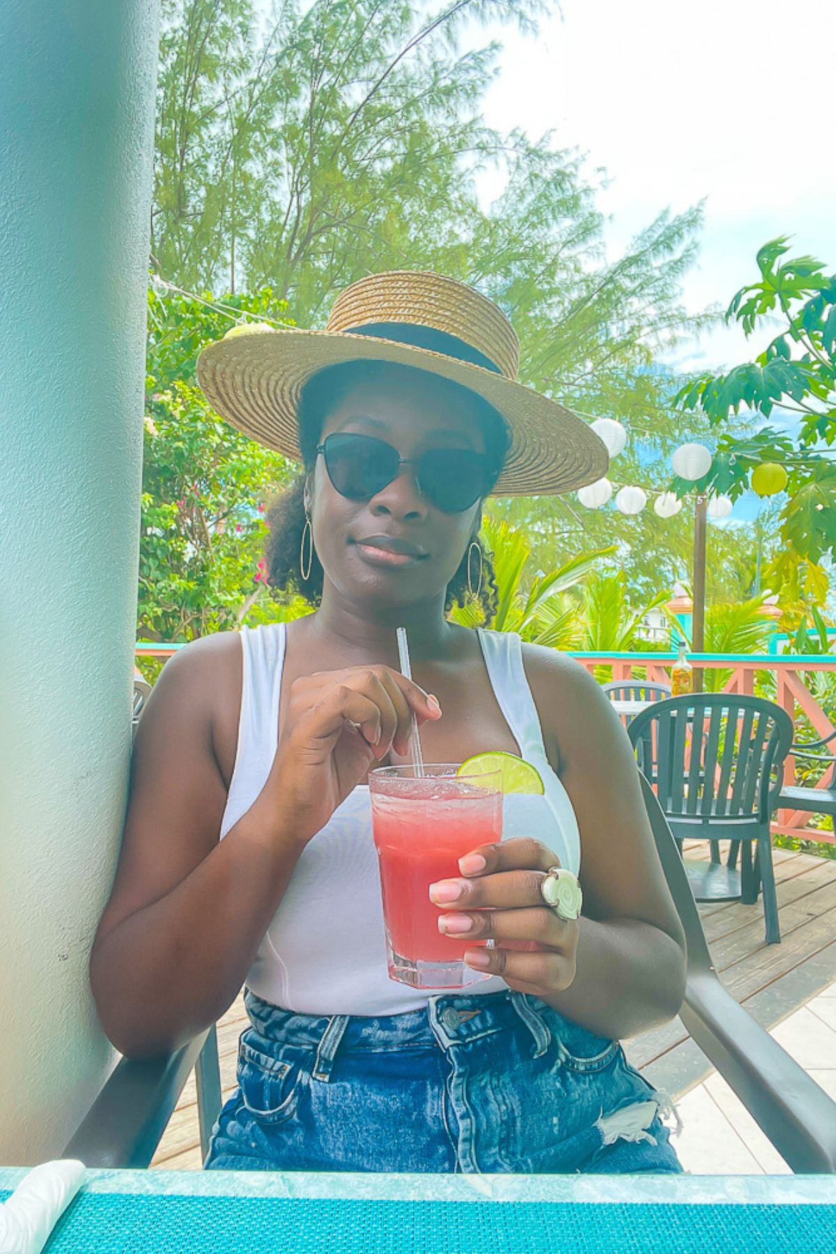 Jazzmine having lunch in Turks and Caicos in a casual Caribbean vacation outfit, complete with a straw boater hat.