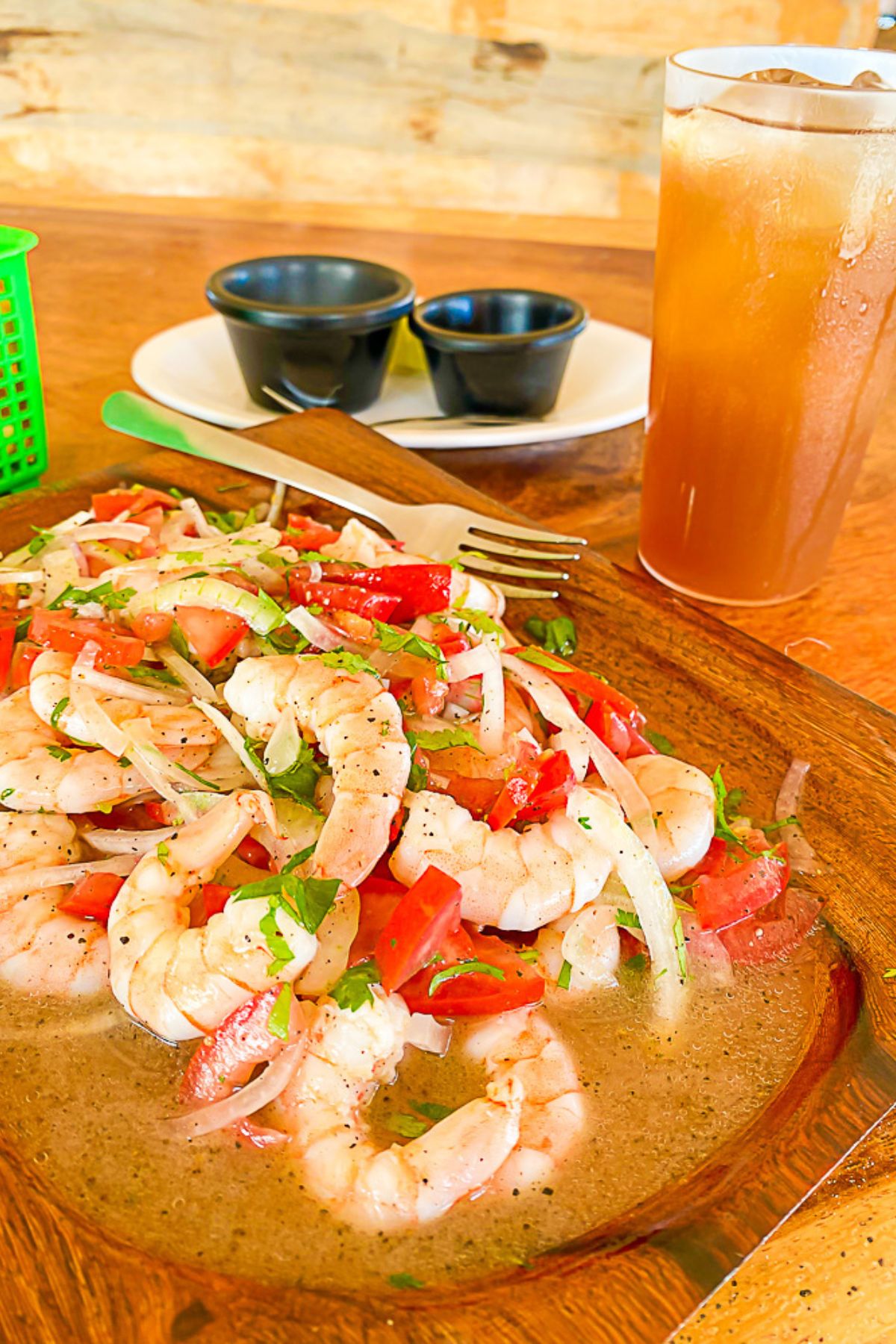 platter of shrimp aguachile with a glass of tamarindo agua fresca at dinner restaurant in Isla Holbox, MX.