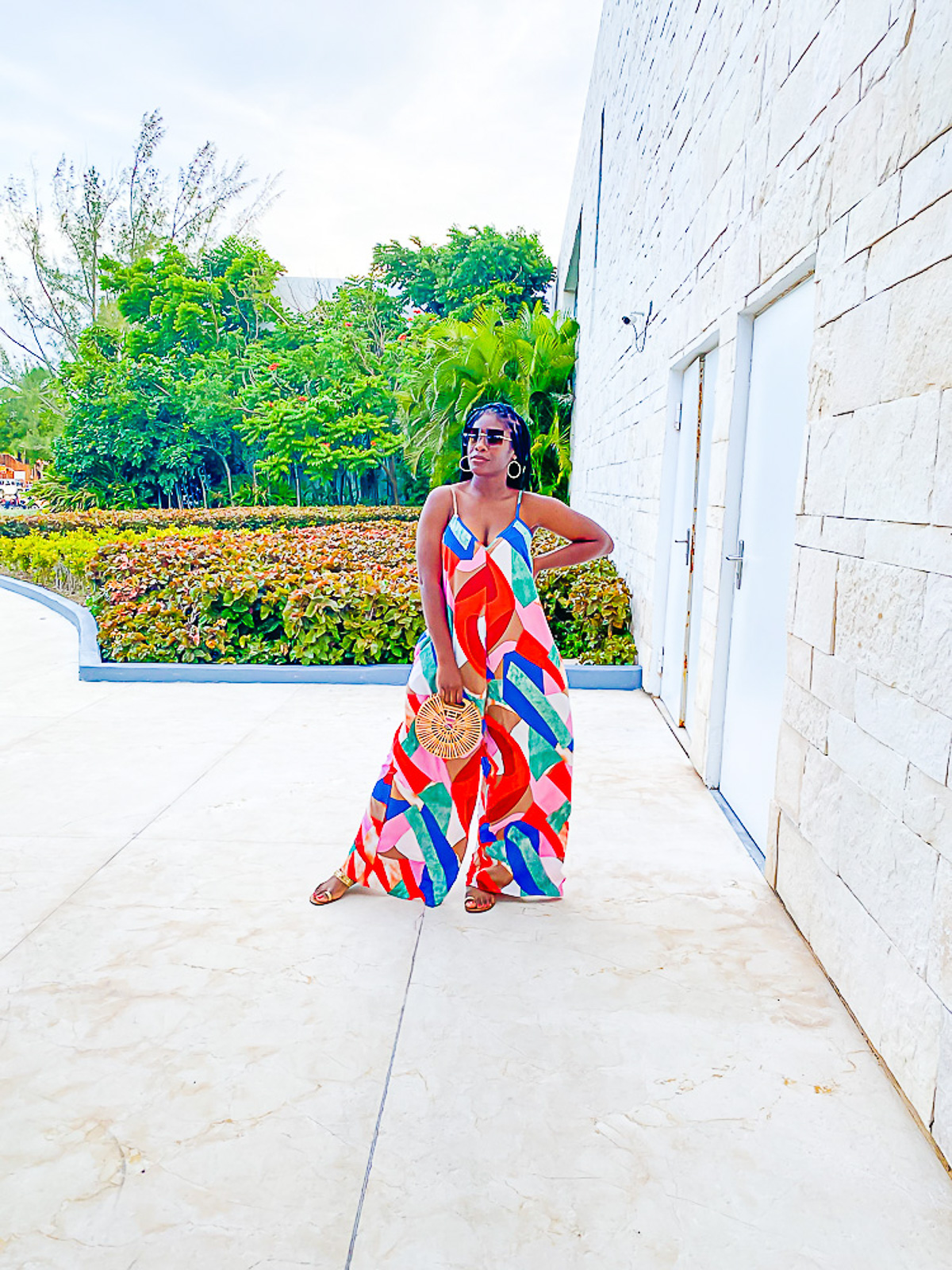 Jazzmine wearing a colorful wide-leg jumpsuit and sunglasses in Cozumel's hotel zone.