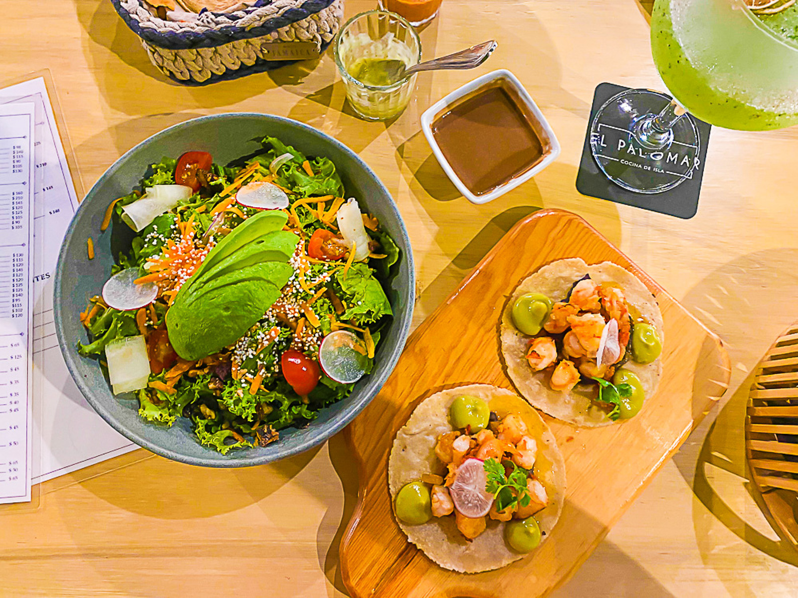 shrimp tacos, green gin cocktail, and salad with fresh avocado on El Palomar's patio en Cozumel.