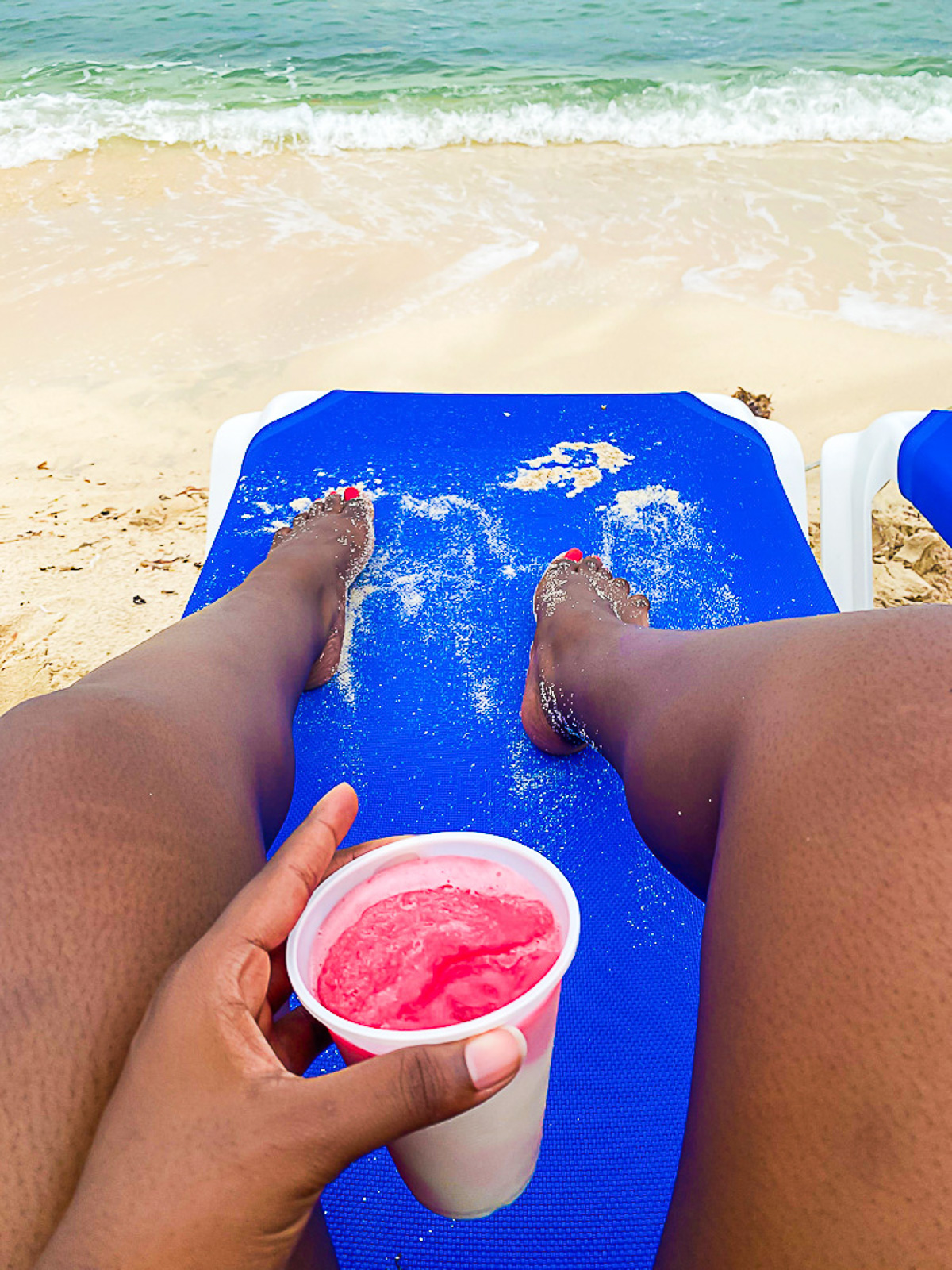 solo woman traveler laying out at Mr. Sancho's beach club with a frozen cocktail.
