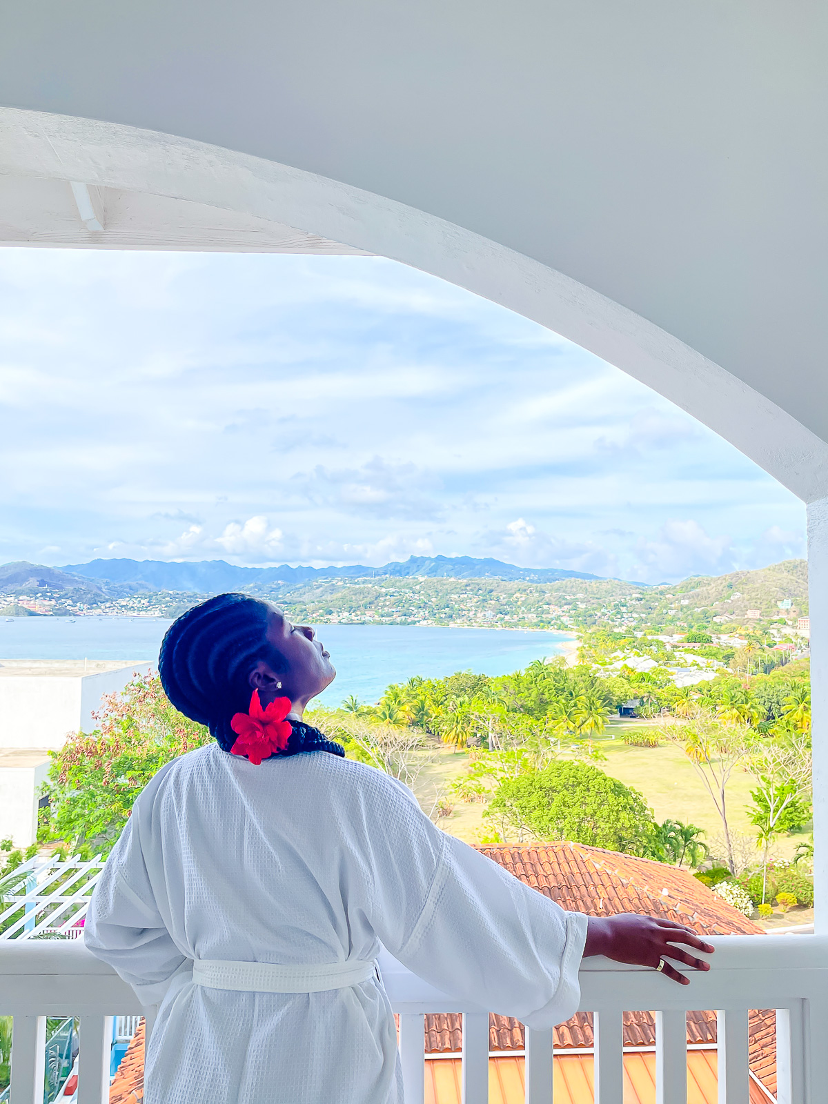 Jazzmine looking out at Grand Anse Beach from Caribbean hotel room balcony.