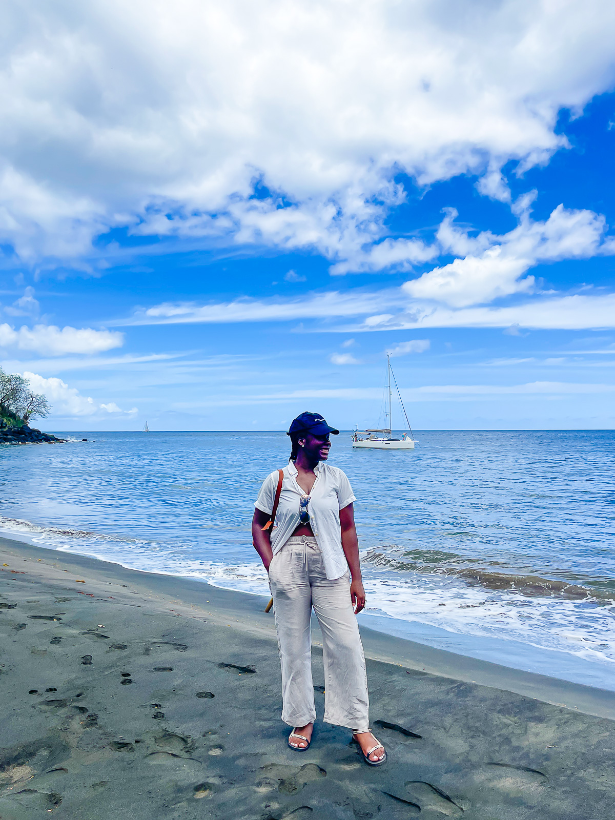 Jazzmine standing in black volcanic sand on Black Bay Beach in Grenada.
