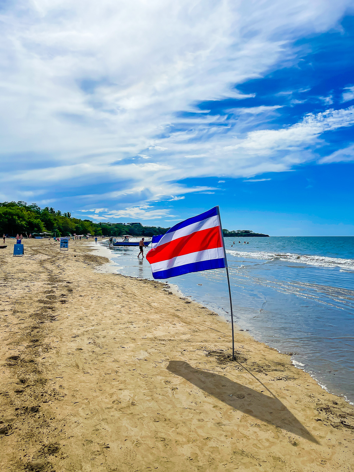 Costa Rica flag flying in the sand at the shoreline of Playa Tamarindo in Costa Rica.